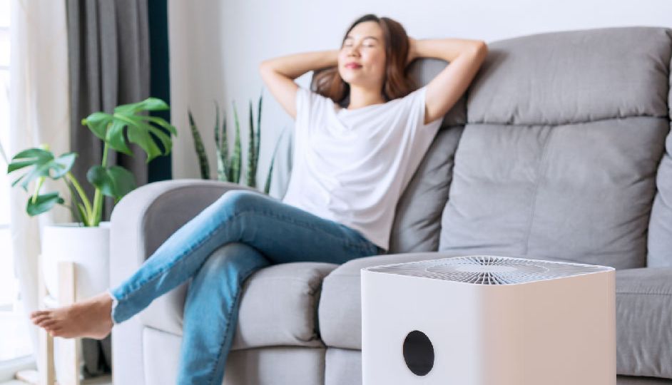 asian-woman-relaxing-comfortable-sofa-home-with-purifier-beside-01